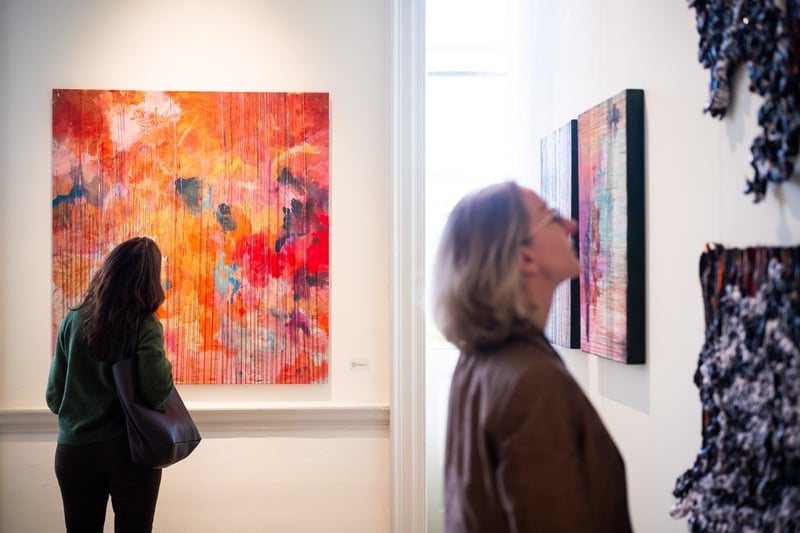Visitors viewing contemporary African art at Guns and Rain